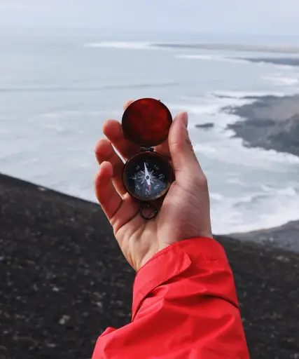 Person holding compass by Garrett Sears.