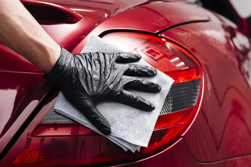 Close up of person cleaning car exterior by Freepik