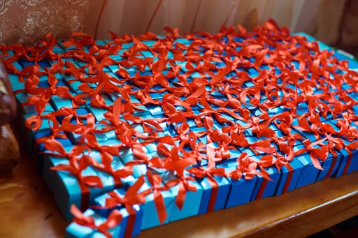 Little blue gift boxes with red ribbons lie on a table by Freepik