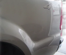 Demonstration of a bodywork with a bumper dent with scratches.